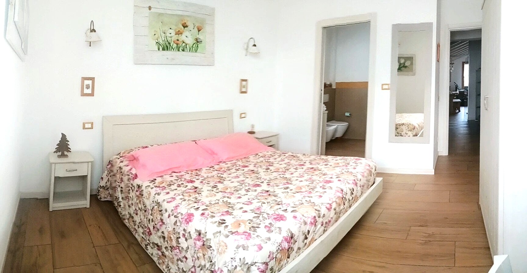 Letto matrimoniale con copriletto floreale nella Camera Mimosa