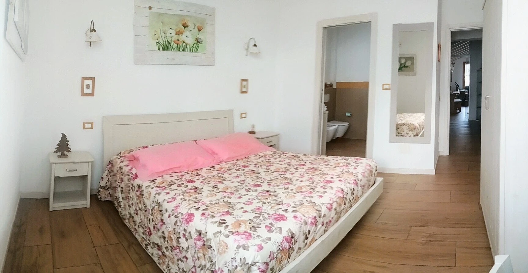 Lit double avec couvre-lit à fleurs dans la chambre Mimosa