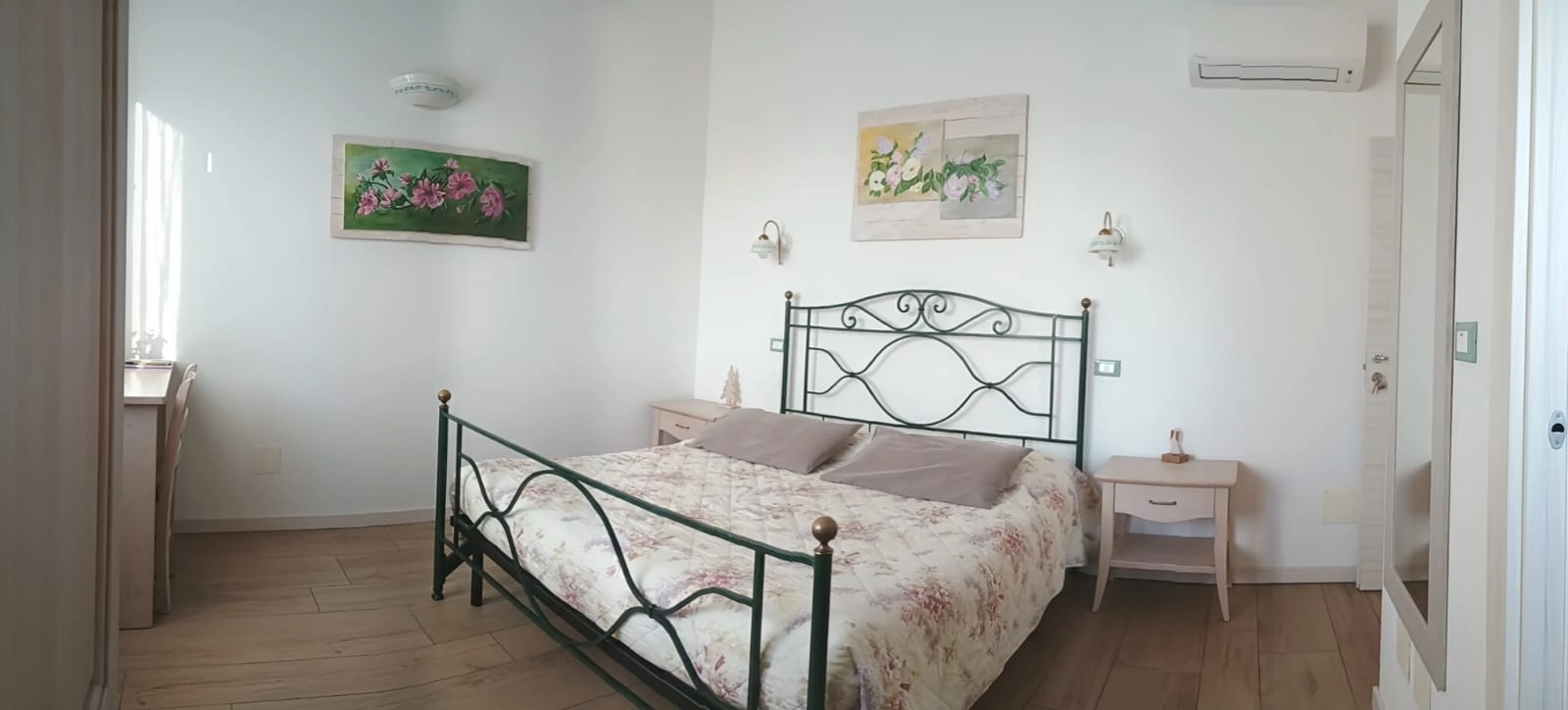 Letto matrimoniale con copriletto floreale nella Camera Mimosa