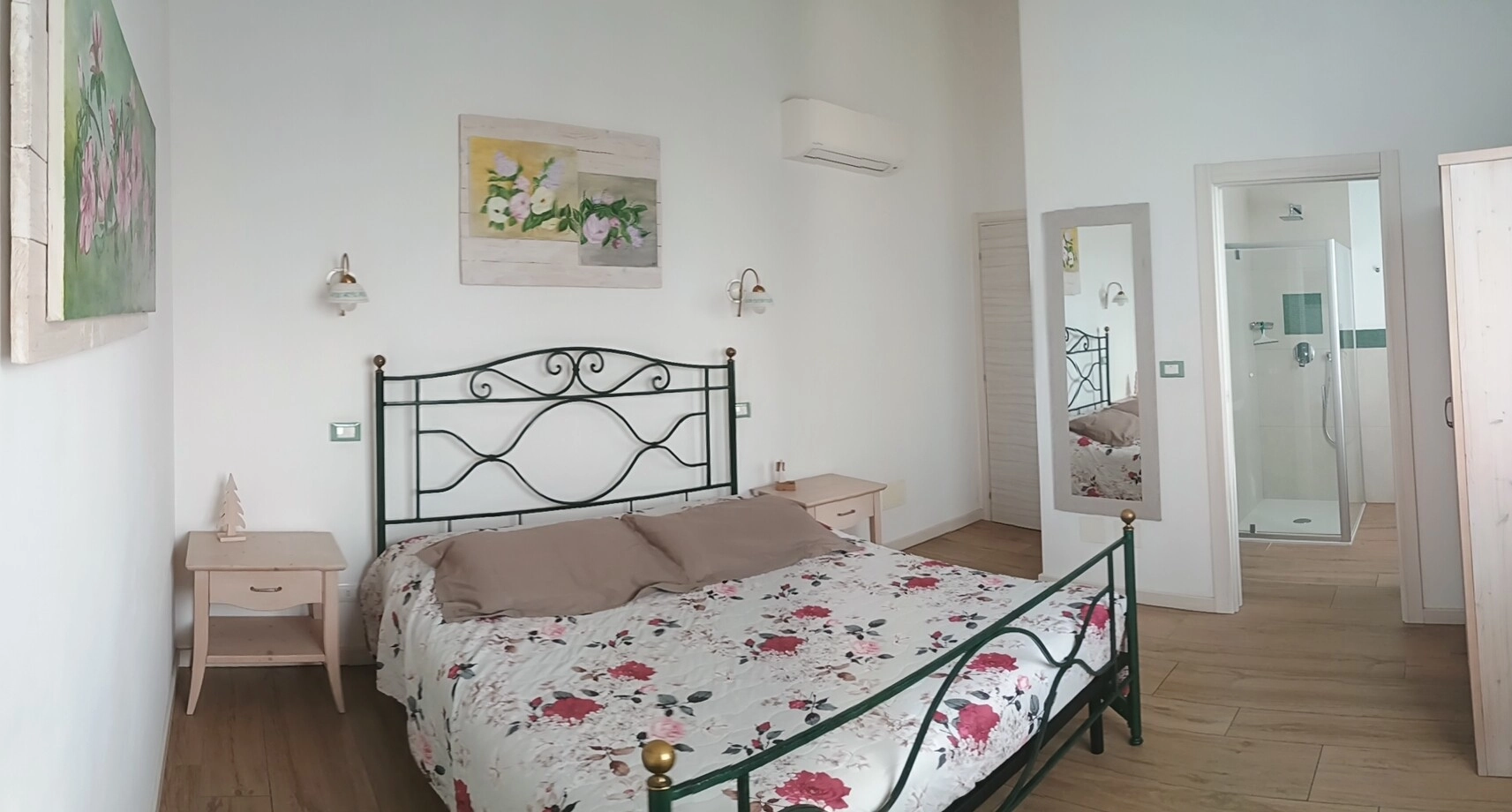 Letto matrimoniale con copriletto floreale nella Camera Lilla